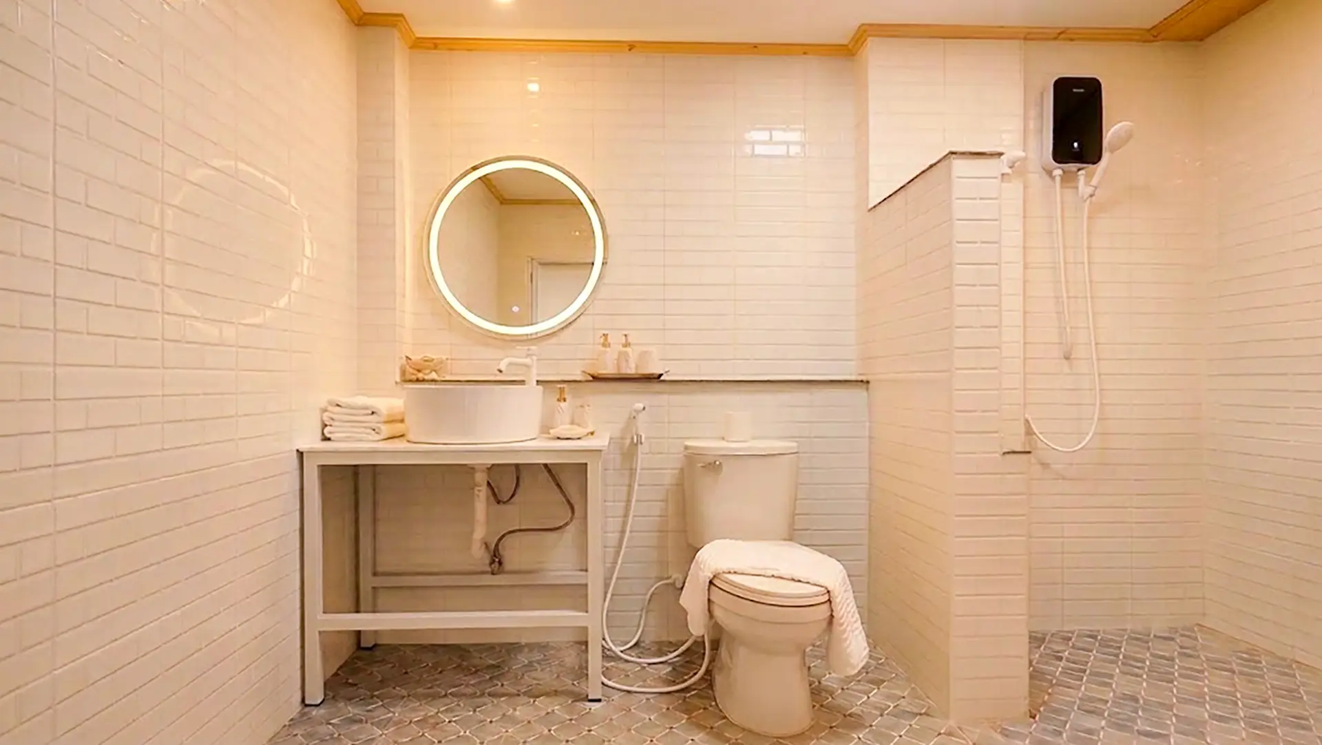 En-suite bathroom with round LED mirror, vessel sink, and walk-in rain shower at Panpurie Garden Terrace room